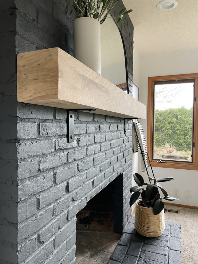 Fireplace Mantel Featuring Charcoal Brick Surround and Wood
