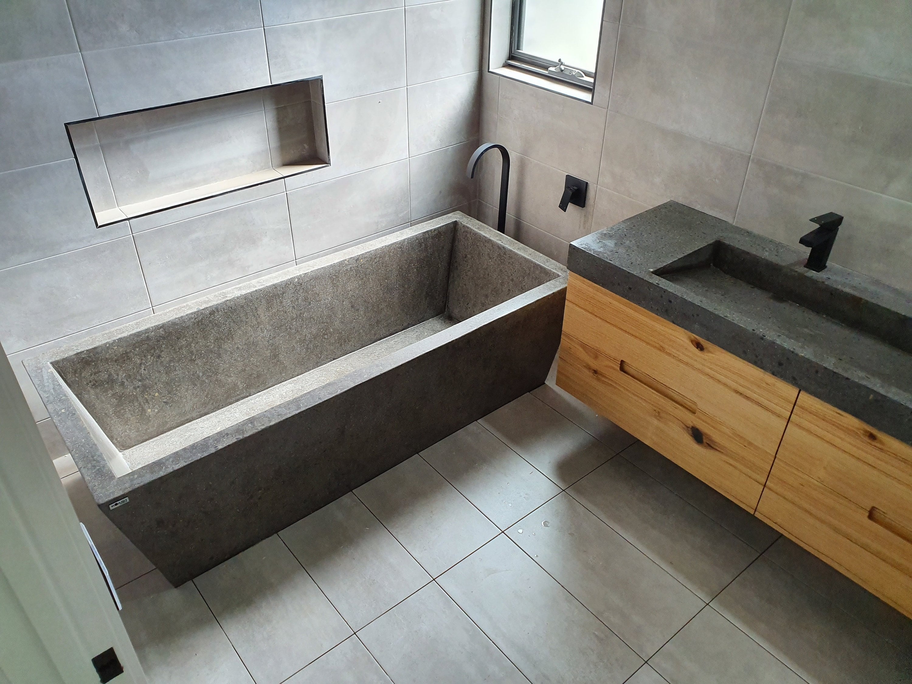 Freestanding Bathtub in Polished Concrete with Exposed Stone