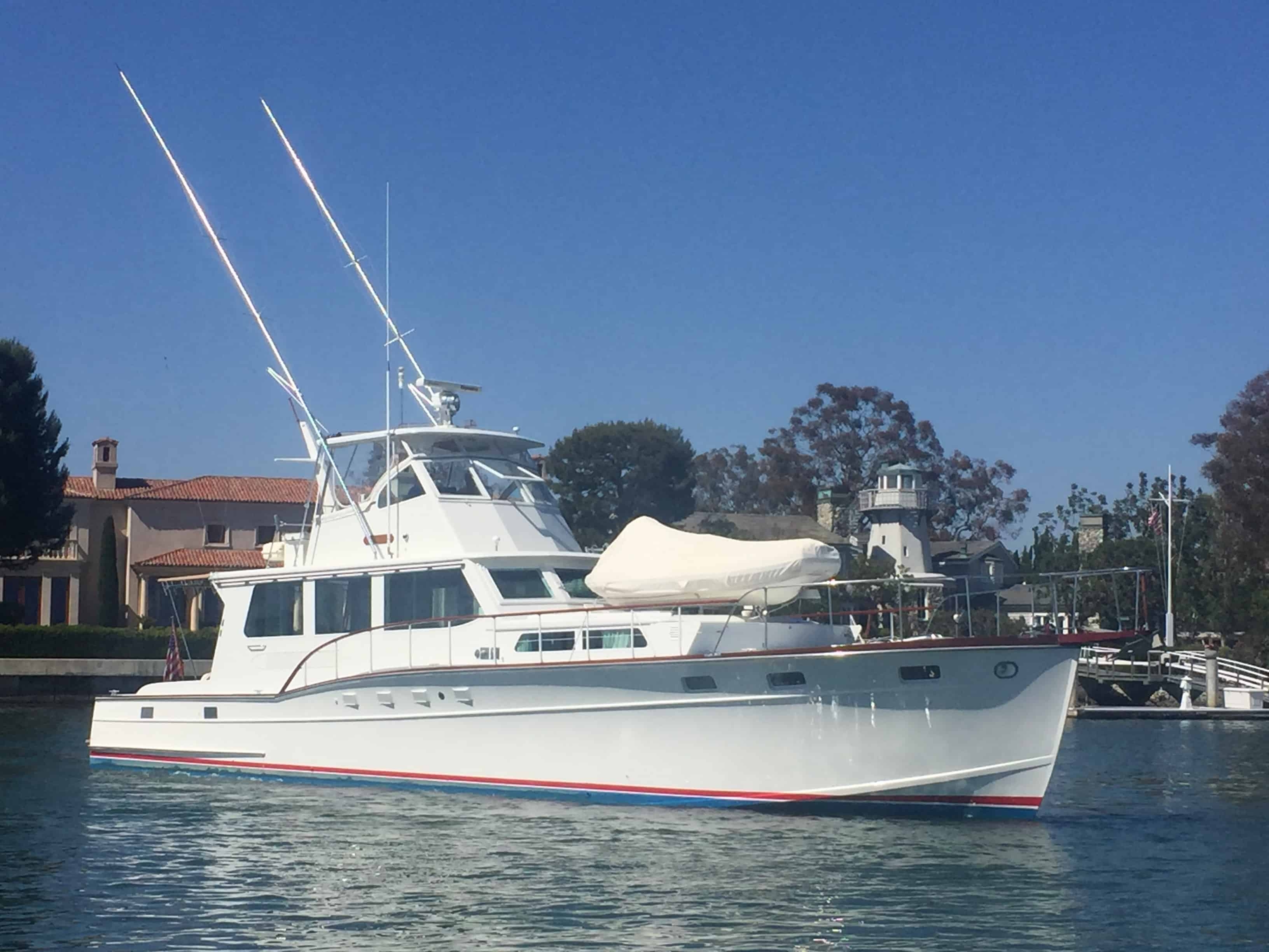 Motor Yacht with Dual Outriggers and White Huckins Sportsman Boat