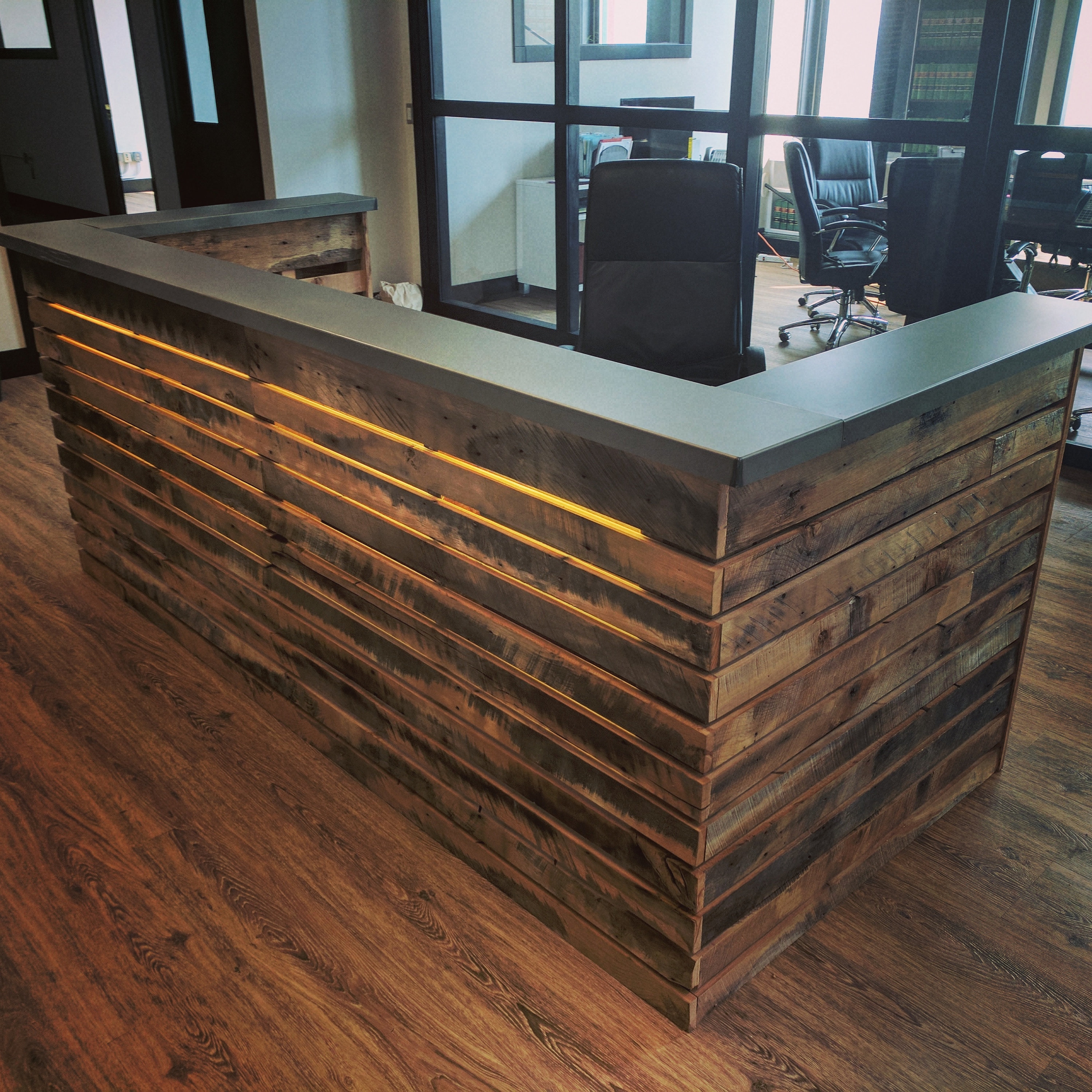 Reception Desk with Illuminated Slats and Backlit Wood Design