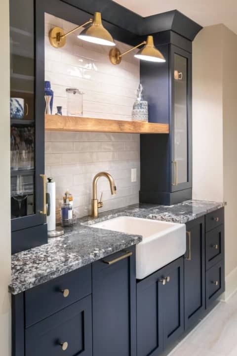 Wet Bar Featuring Brass Swing Arm Lights And Farmhouse Sink