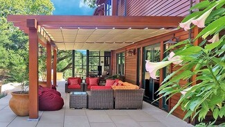 Attached Pergola With Retractable Shade and Red Seating