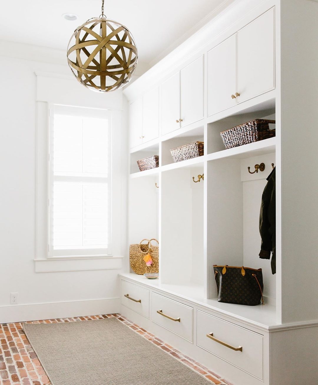 Built In Mudroom with Brick Flooring and Orb Pendant Light