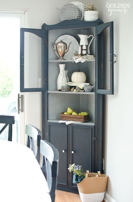 Corner Cabinet featuring Wire Mesh Doors and Scalloped Trim
