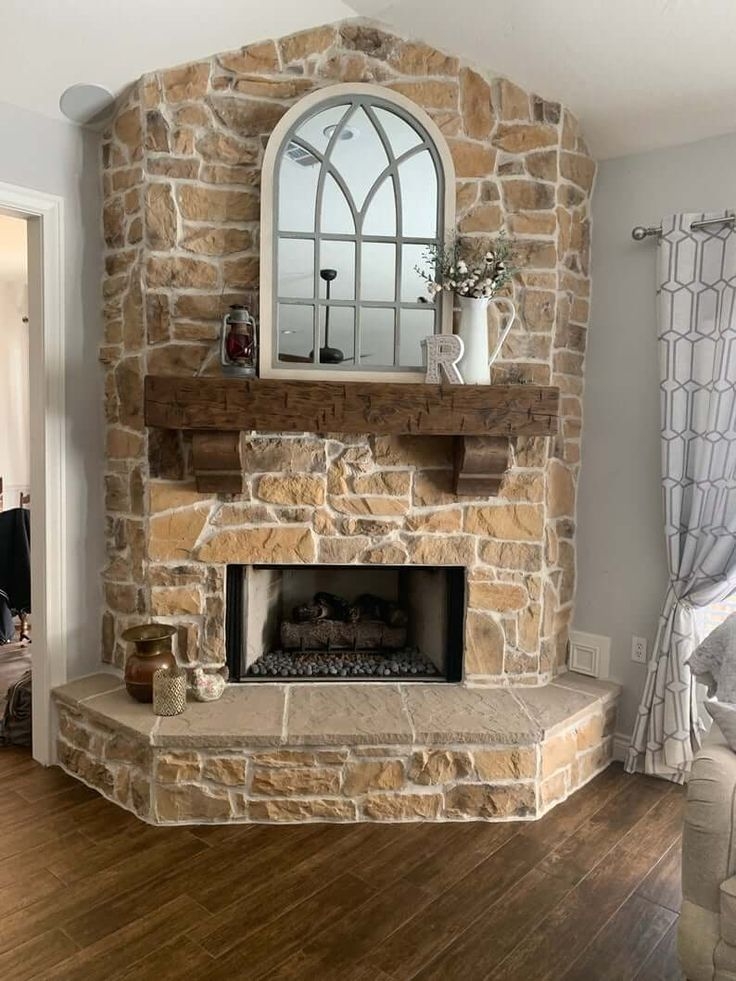 Corner Fireplace With Rustic Stone Surround And Arched Mirror
