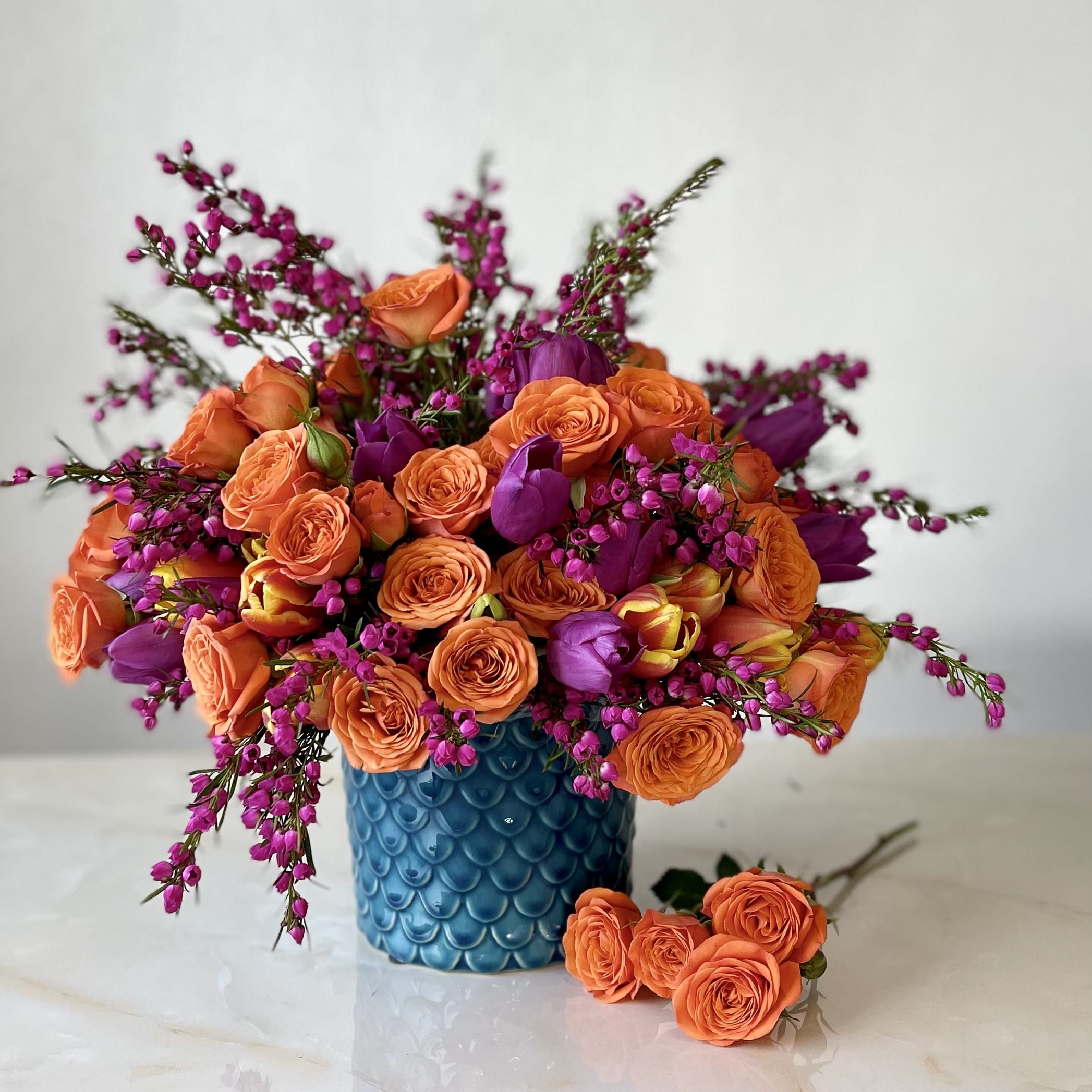 Floral Arrangement in Scalloped Blue Vase with Purple Tulips