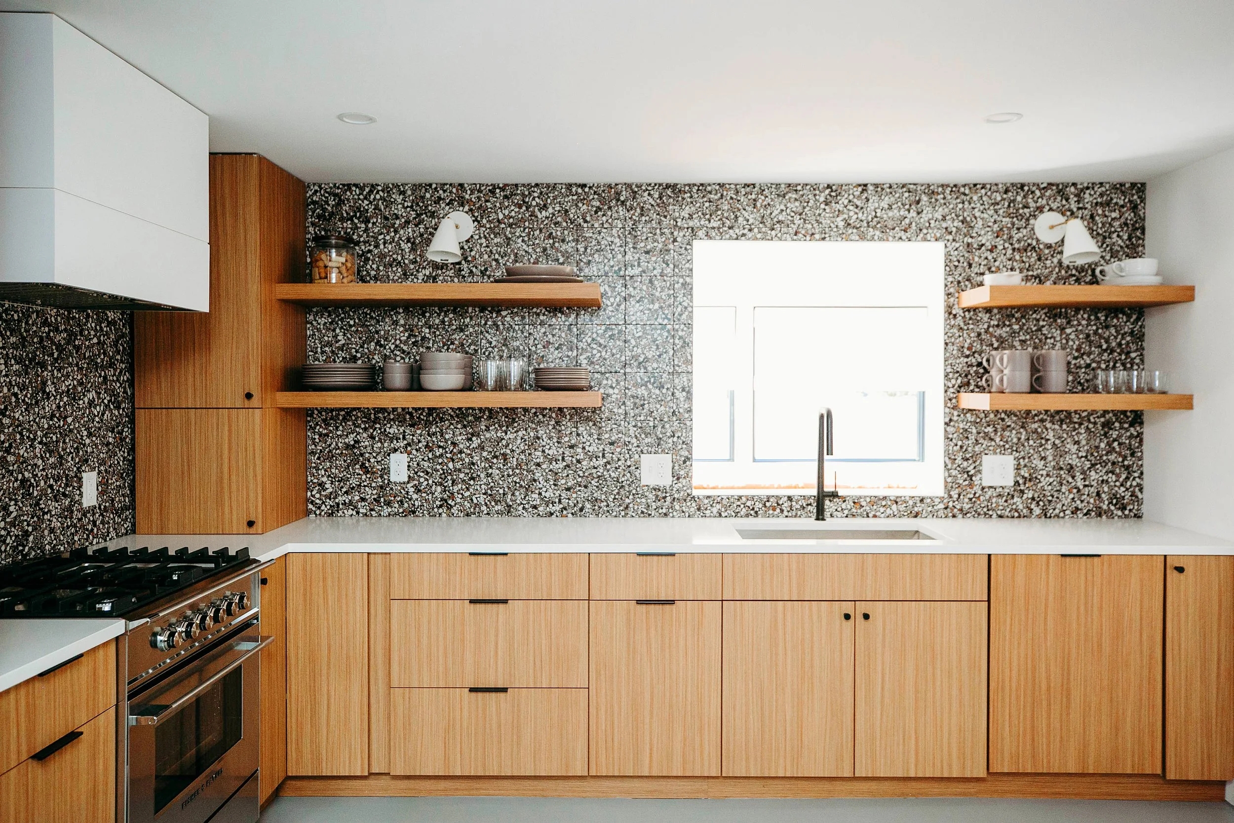 Kitchen Cabinetry Featuring Terrazzo Backsplash and Shelves