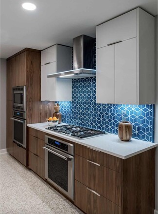 Kitchen Cabinetry Featuring Walnut Wood and Blue Tile