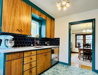 Kitchen Cabinetry With Navy Picket Tile and Teal Trim