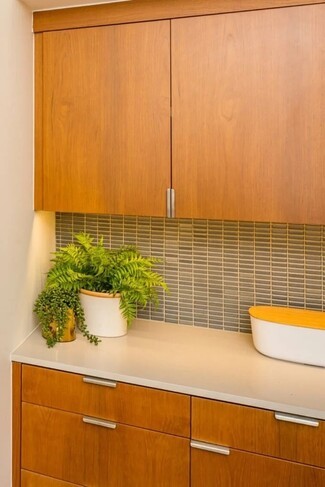 Kitchen Cabinetry With Slab Front Doors and Vertical Tile