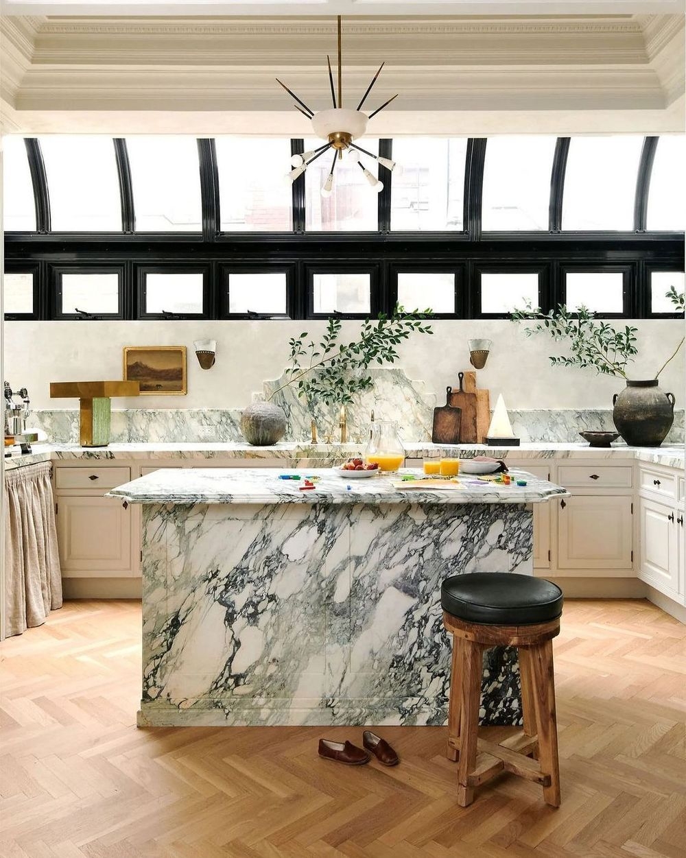 Kitchen Island with Dramatic Veined Marble and Arched Windows