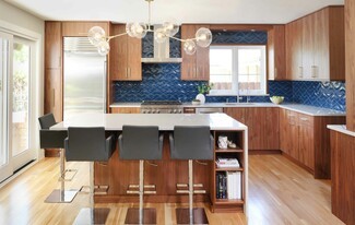 Kitchen Island With Walnut Cabinetry and Navy Chevron Tile