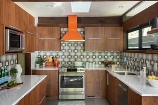Mid Century Kitchen Featuring Orange Range Hood and Retro