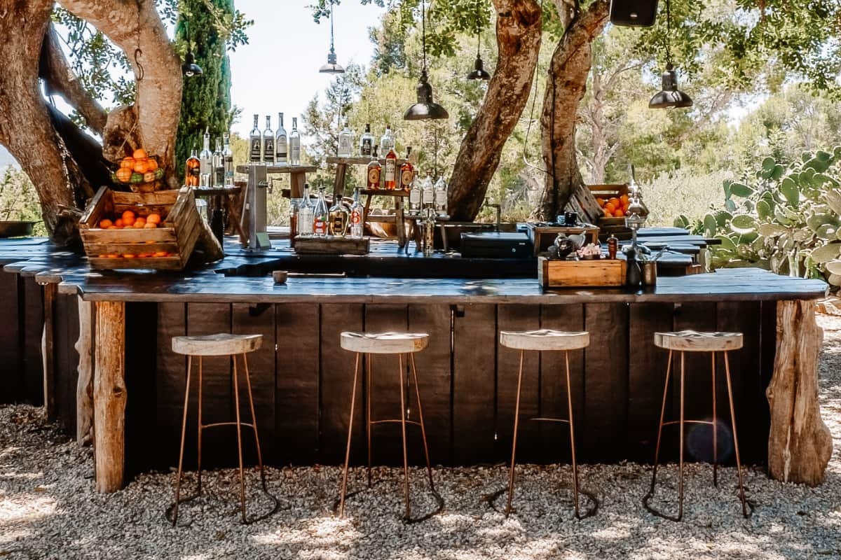 Outdoor Bar with Tree Trunk Pillars and Dark Plank Facade