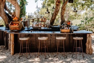 Outdoor Bar with Tree Trunk Pillars and Dark Plank Facade