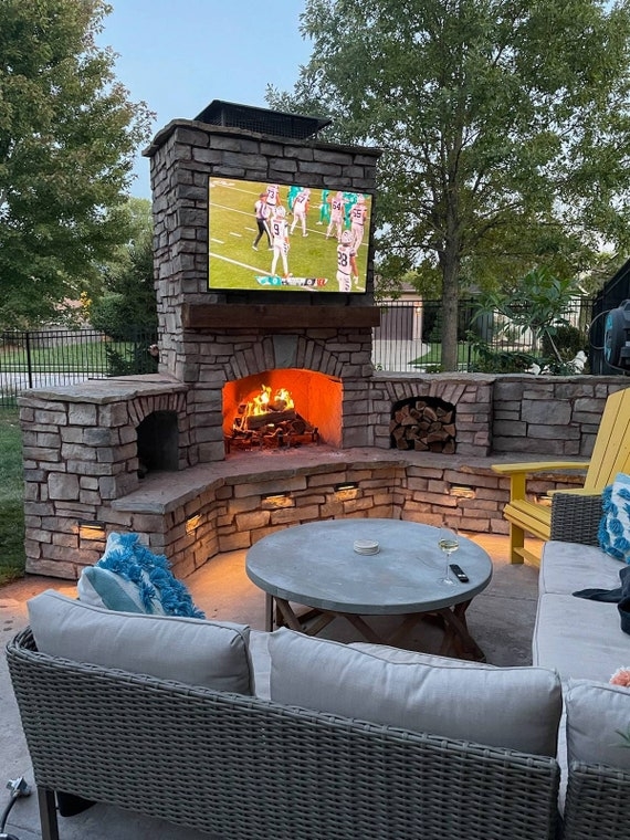 Outdoor Fireplace Featuring Integrated Base LED Lighting and TV
