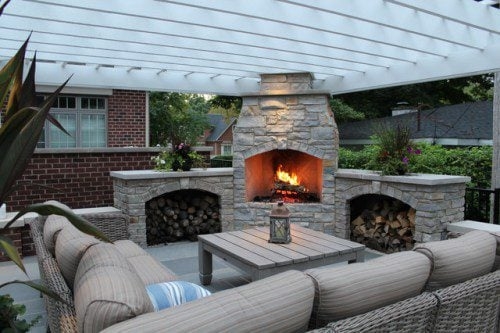 Outdoor Fireplace with Dual Wood Alcoves and White Pergola